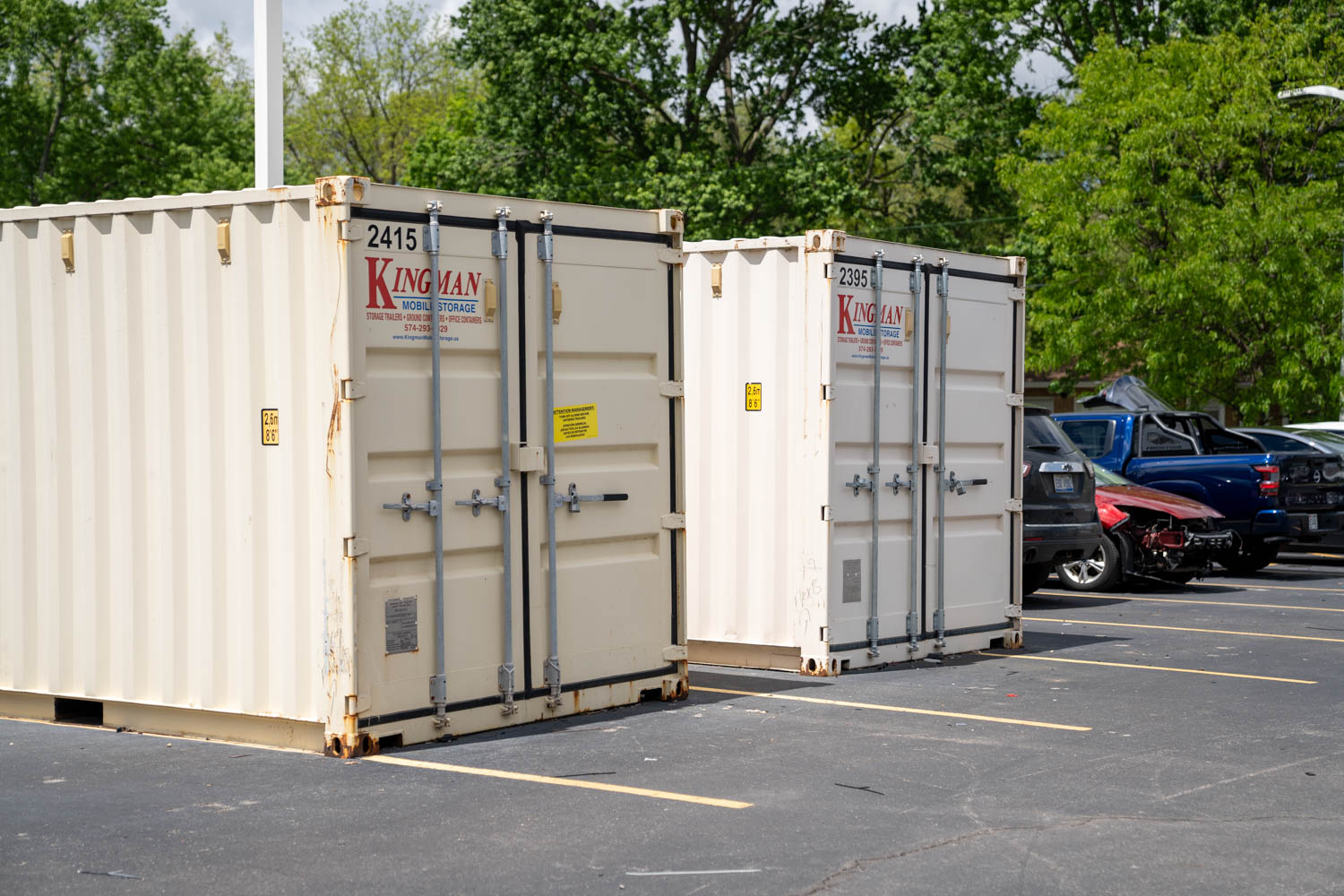 Two mobile storage containers sitting by each other in a parking lot